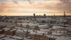 Sniegots Rīgas pilsētas panorāmas skats no augstceltnes rudenīgā dienā.