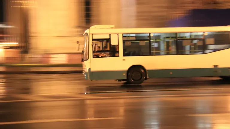 Balts autobuss brauc pa nakts pilsētas ielu radot steigas un spriedzes sajūtu.